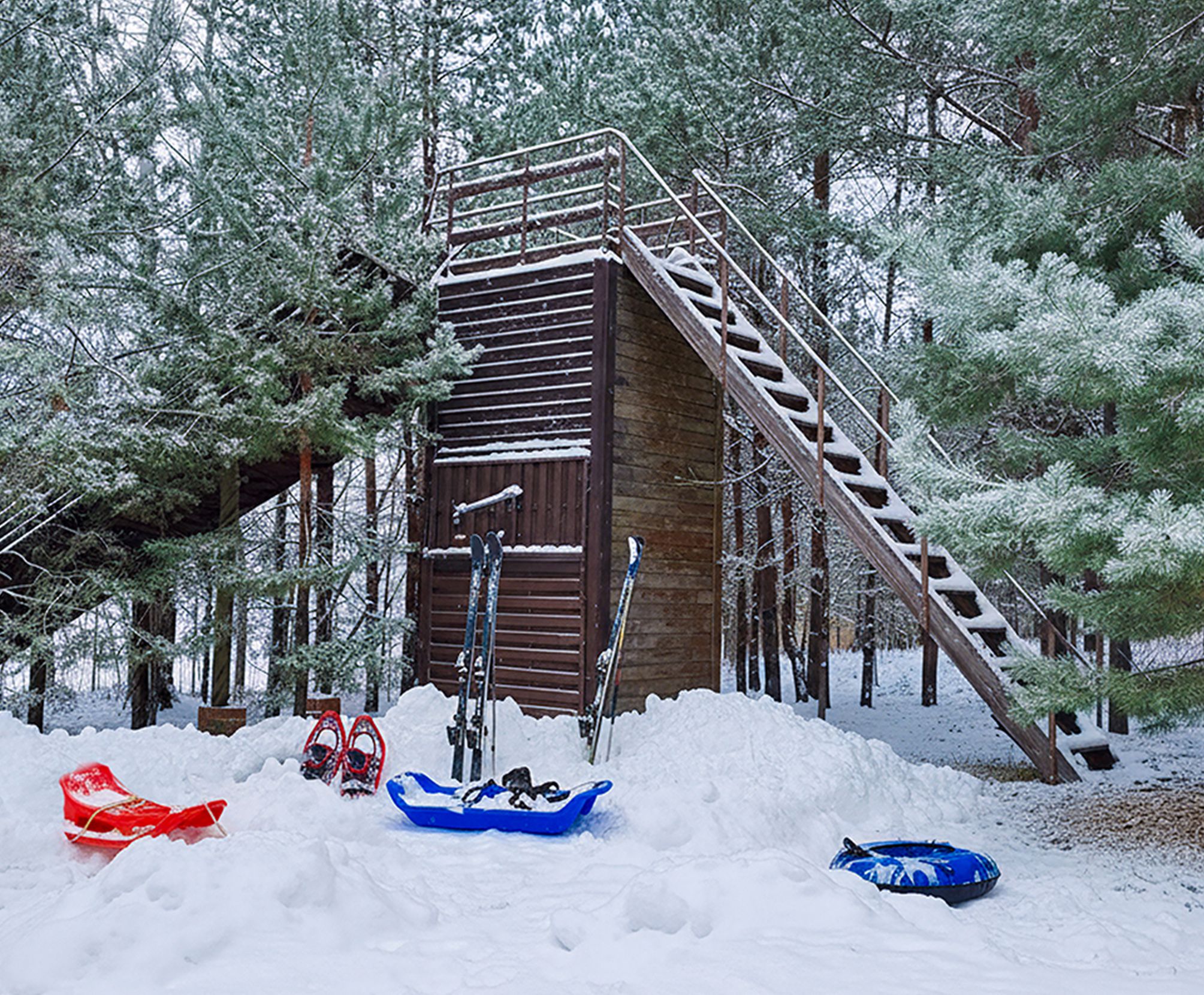 Зимняя игровая зона с горкой и тюбингами в сосновом лесу
