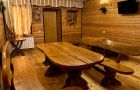 Комната отдыха в бане с деревянным столом и лавками