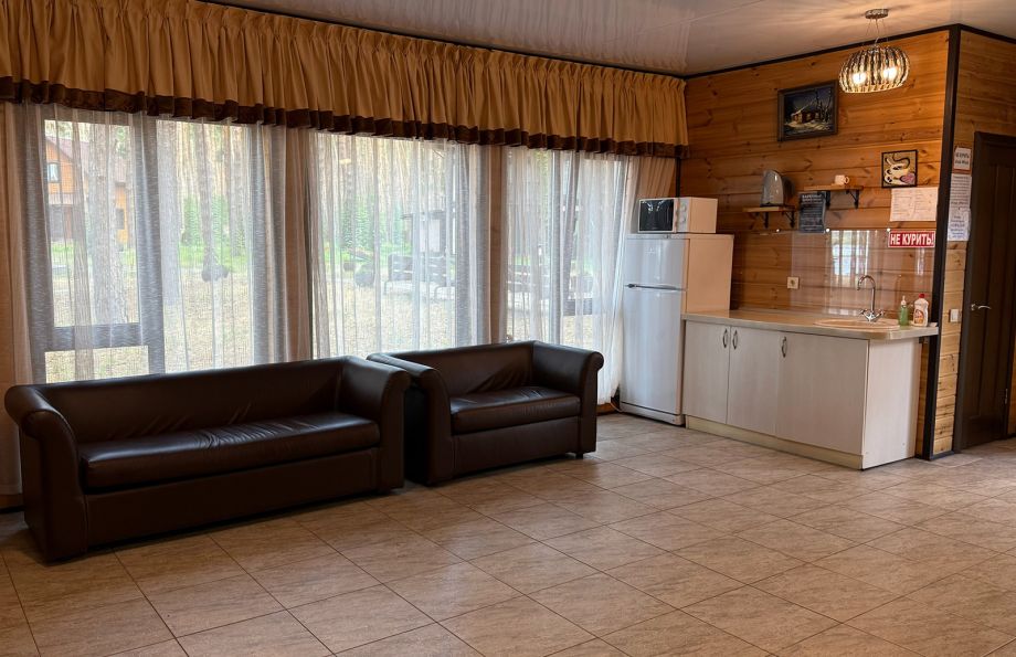 Закрытая каменная беседка с массивной мебелью для отдыха в любую погоду