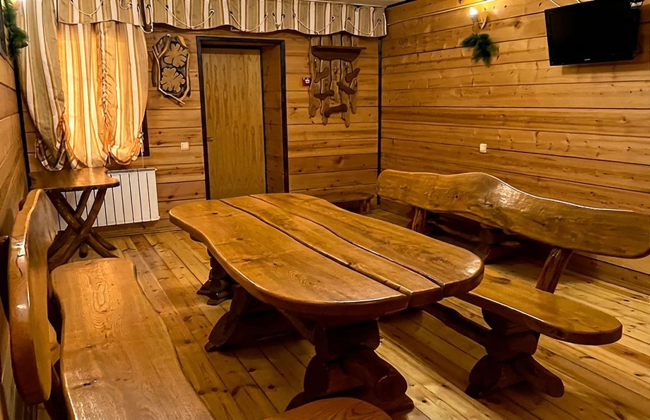Комната отдыха в бане с деревянным столом и лавками